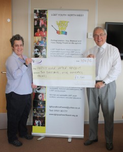 Rachel Williams from LGBT Northwest receiving the cheque from Commissioner John Dwyer.
